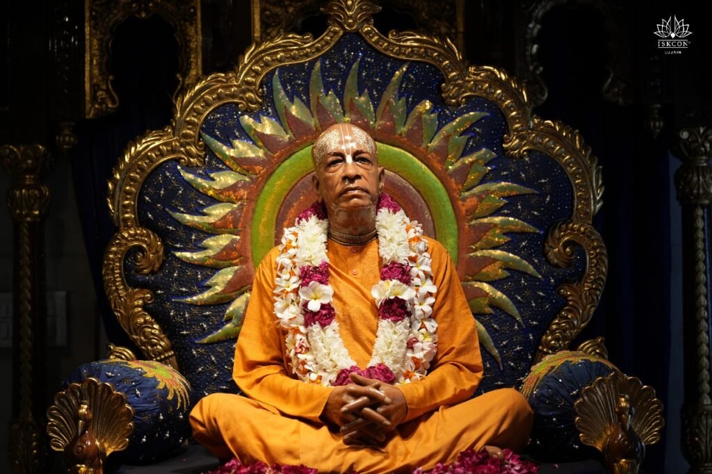 Srila Prabhupada seated on vyasasana with flower garland